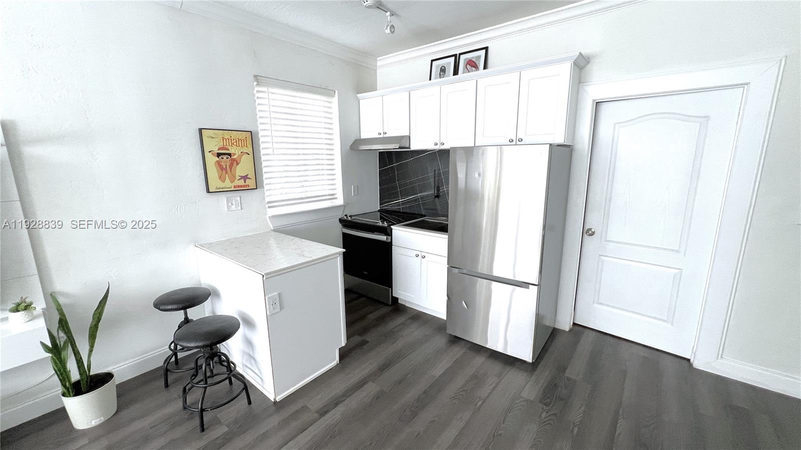 1115 Euclid Avenue, Unit 2 Miami Beach, FL 33139 - Photo 8 of 11 a kitchen with stainless steel appliances a refrigerator stove and wooden floor