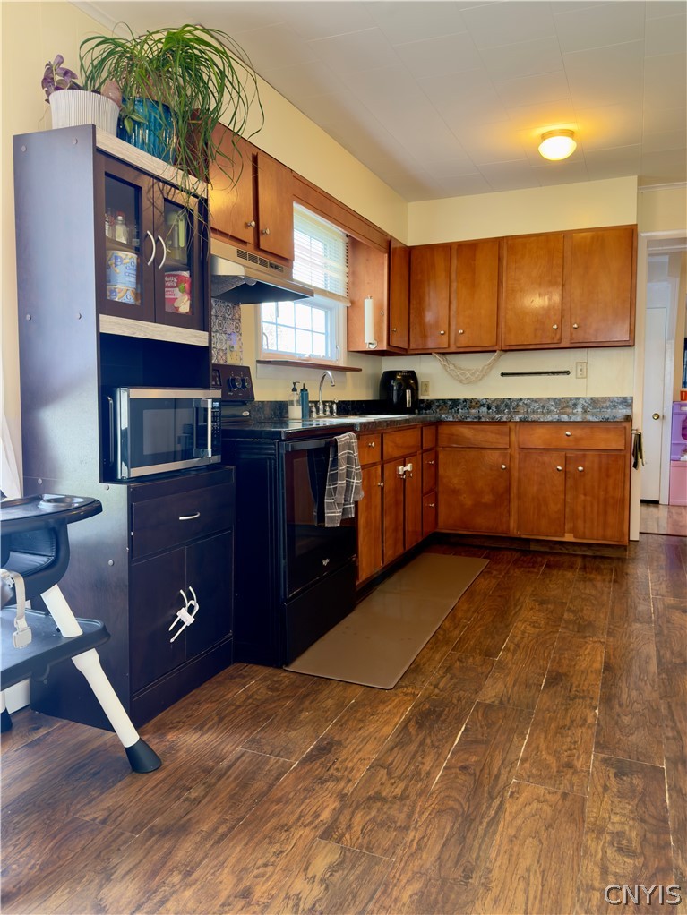 7468 Willey Road Hamilton, NY 13332 - Photo 7 of 19 Rich wood cabinetry paired with dark stone-look countertops anchor this warm, inviting culinary space.