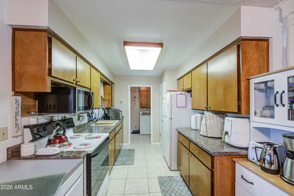 a kitchen with kitchen island granite countertop a sink stove and cabinets