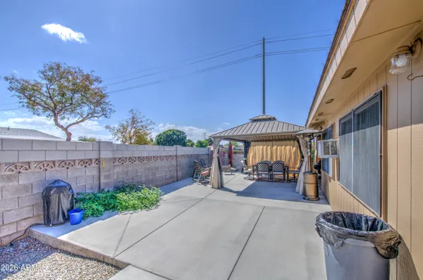a view of a patio with a table and chairs under an umbrella with wooden fence