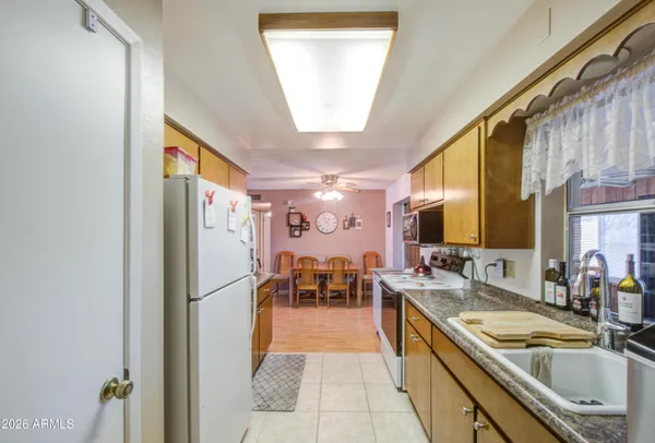 a kitchen with granite countertop a sink and a refrigerator
