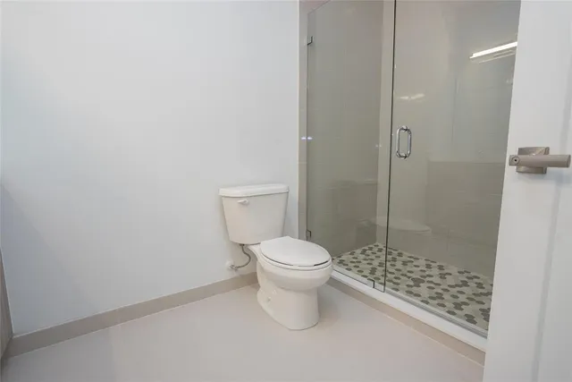 a white toilet sitting next to a shower