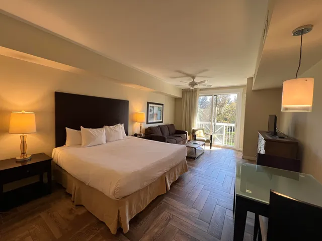 a large bedroom with bed and large windows