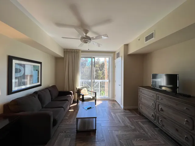 a living room with furniture a flat screen tv and a window