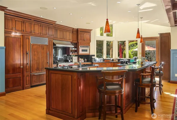 a kitchen with large cabinets appliances and furniture