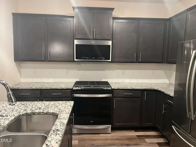 a kitchen with a sink stove and microwave