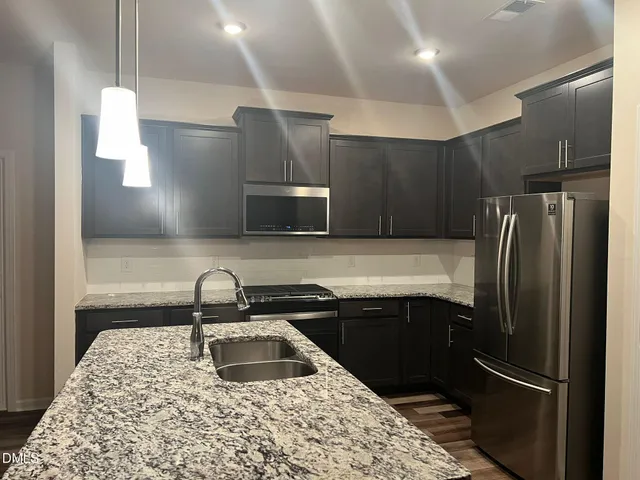 a kitchen with stainless steel appliances granite countertop a sink stove and refrigerator