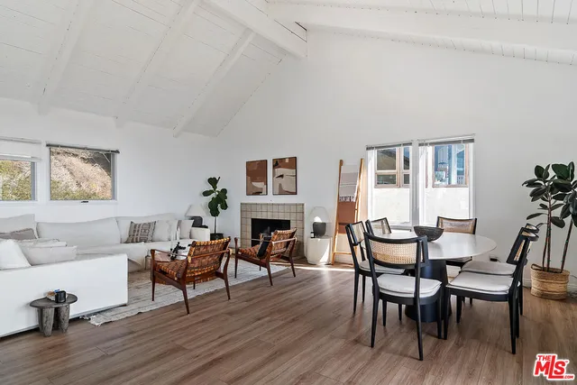 a living room with furniture a fireplace a dining table and a potted plant