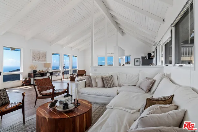 a living room with furniture couches and a dining table with kitchen view