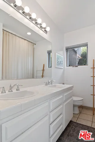 a bathroom with a sink a toilet and a mirror