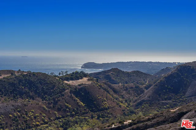 a view of a large building with mountains in the background