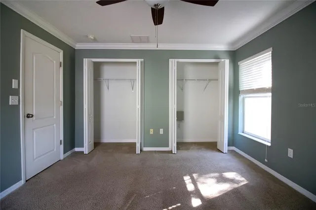 an empty room with windows and cabinet