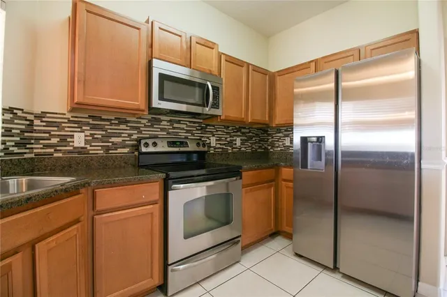 a kitchen with stainless steel appliances granite countertop a stove a microwave and a refrigerator