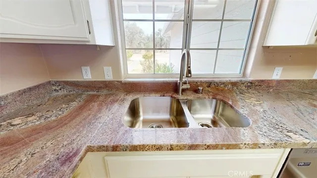 a kitchen with granite countertop cabinets stainless steel appliances and a counter space