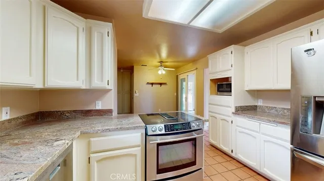 a kitchen with stainless steel appliances granite countertop a refrigerator and a stove