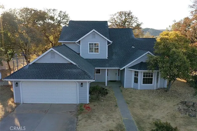 a view of a house with a yard and large tree