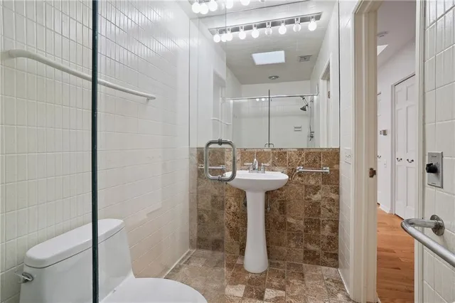 a bathroom with a sink a toilet and shower