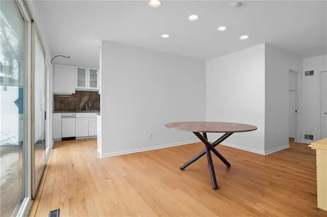 a view of a room with wooden floor a glass door and a window