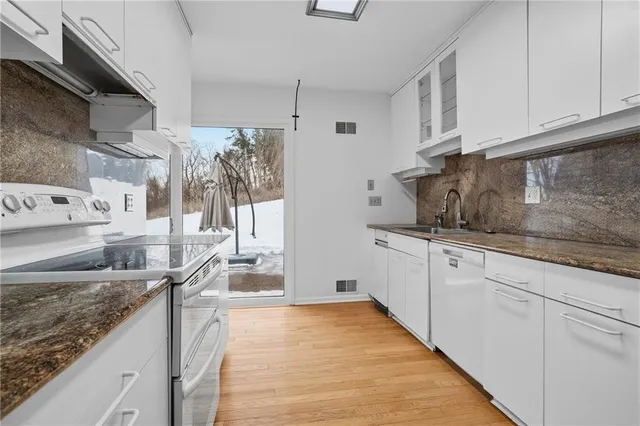 a kitchen with stainless steel appliances granite countertop a sink stove and cabinets