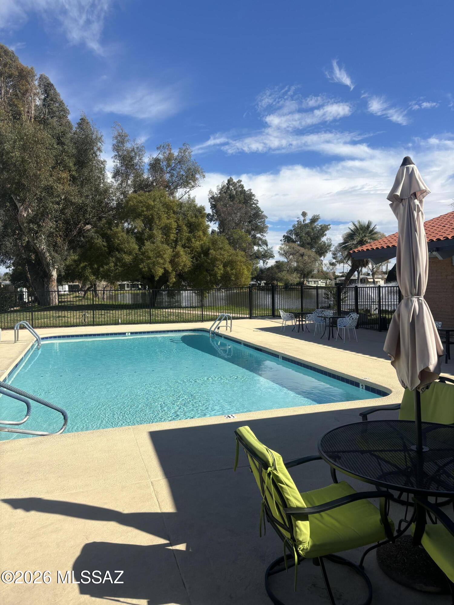 4550 North Flowing Wells Road, Unit 65 Tucson, AZ 85705 - Photo 12 of 50 a view of a swimming pool with an outdoor seating and a yard