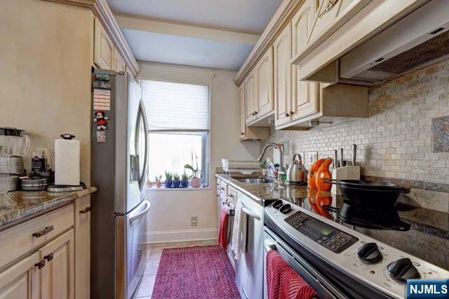 301 Beech Street, Unit 3K Hackensack, NJ 07601 - Photo 21 of 29 a kitchen with stainless steel appliances a sink a stove and a window
