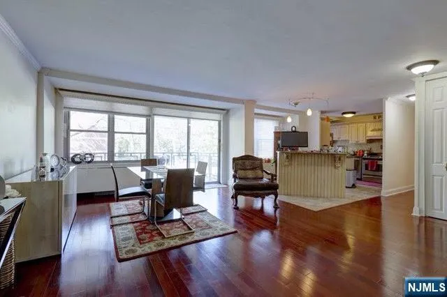 a living room with furniture large window and wooden floor