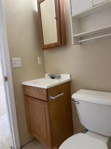 a bathroom with a sink toilet and mirror