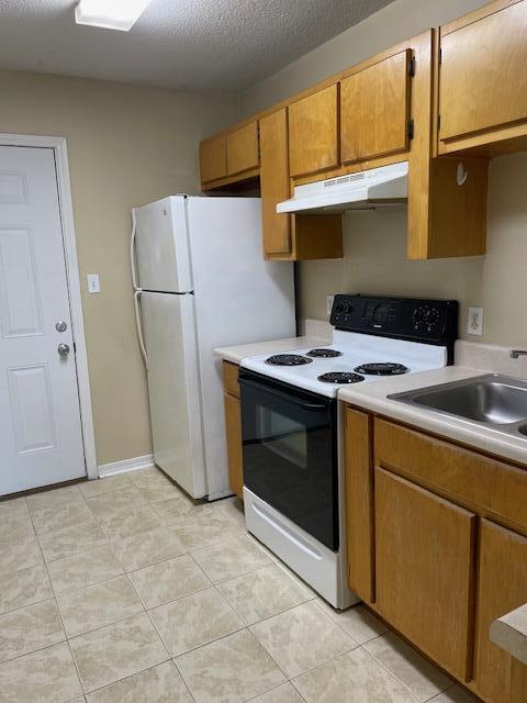 6905 Sea Turtle Circle, Unit E Navarre, FL 32566 - Photo 3 of 13 a kitchen with a stove top oven and refrigerator