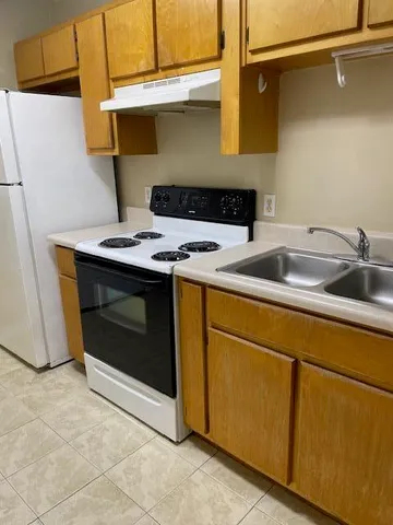 a stove top oven sitting inside of a kitchen