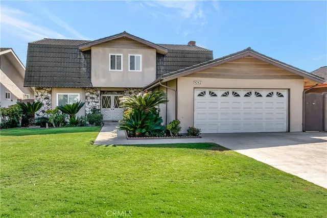 a front view of house with yard and garage