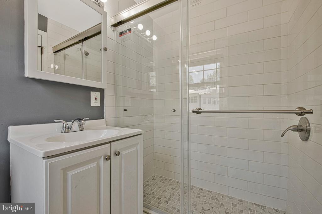 2406 37th Street Northwest Washington, DC 20007 - Photo 32 of 44 a bathroom with a sink a vanity and shower