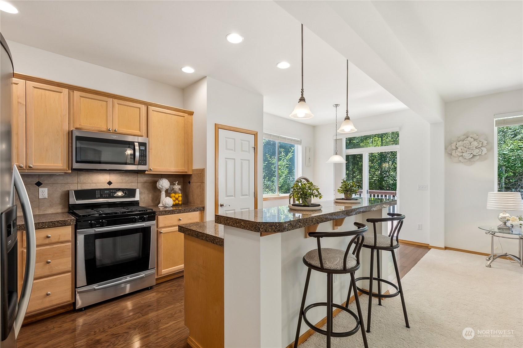 3426 172nd Place Southeast Bothell, WA 98012 - Photo 4 of 33 a kitchen with stainless steel appliances kitchen island granite countertop a stove a sink and a microwave