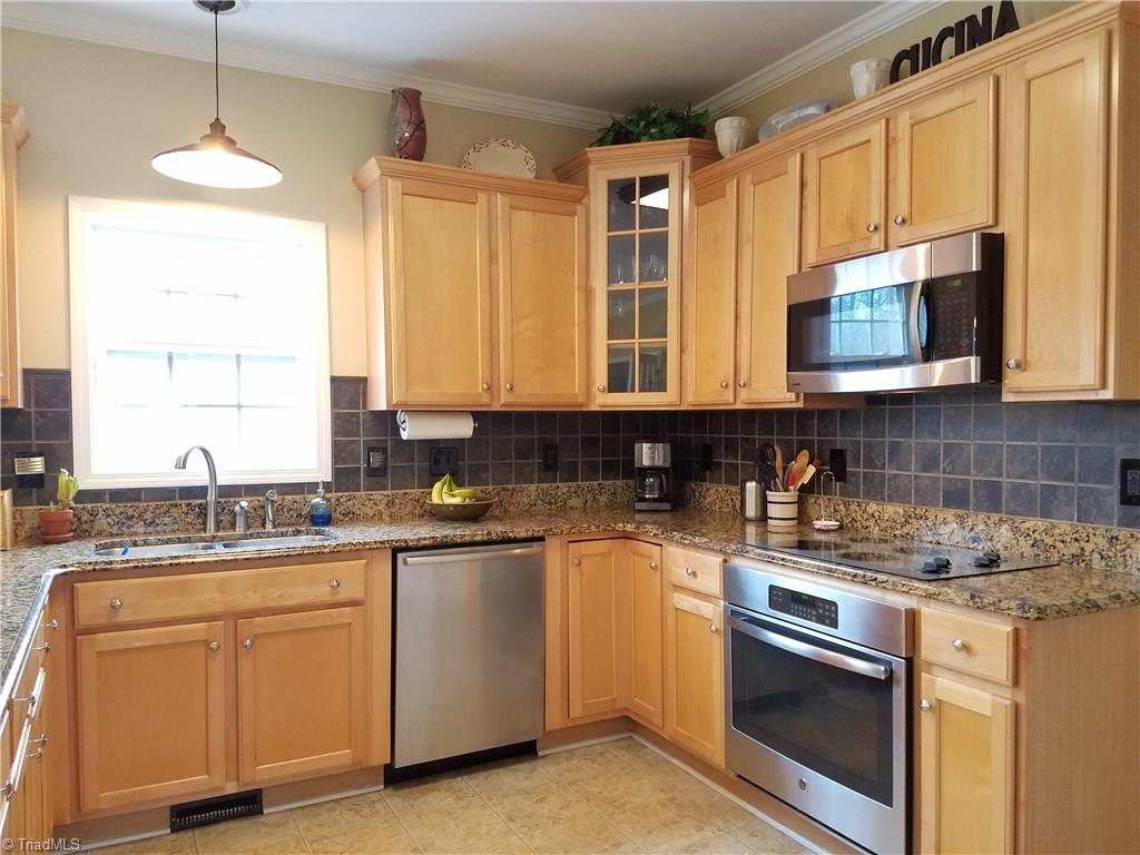 7822 Wilson Farm Road Summerfield, NC 27358 - Photo 7 of 30 Granite countertops, newer SS appliances, tile back splash and cabinet pull-outs