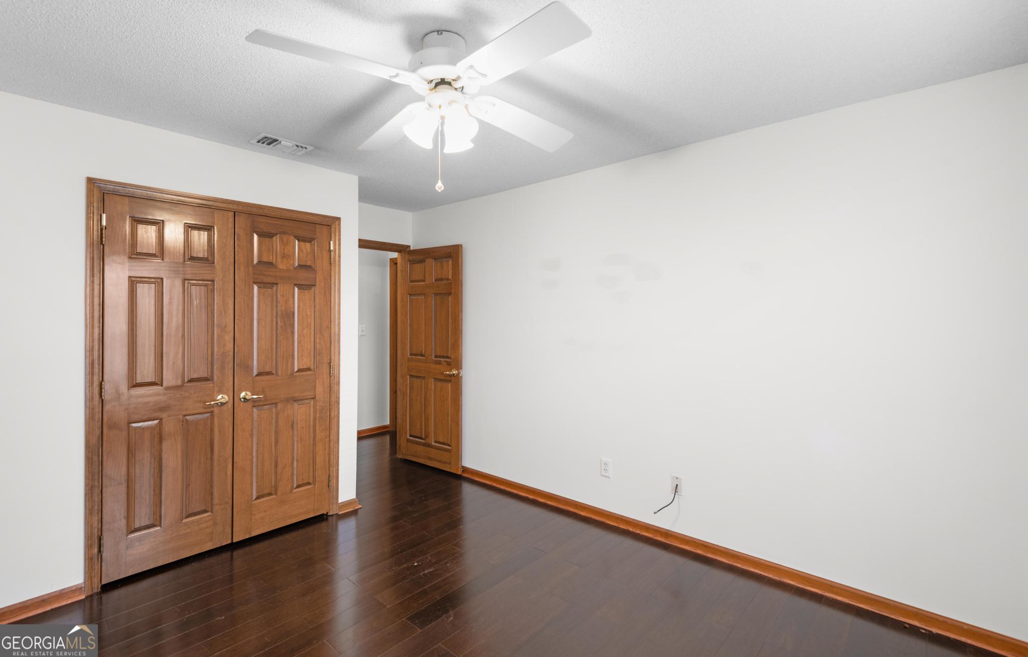 4909 Perry Road Claxton, GA 30417 - Photo 42 of 54 an empty room with wooden floor closet ceiling fan and window