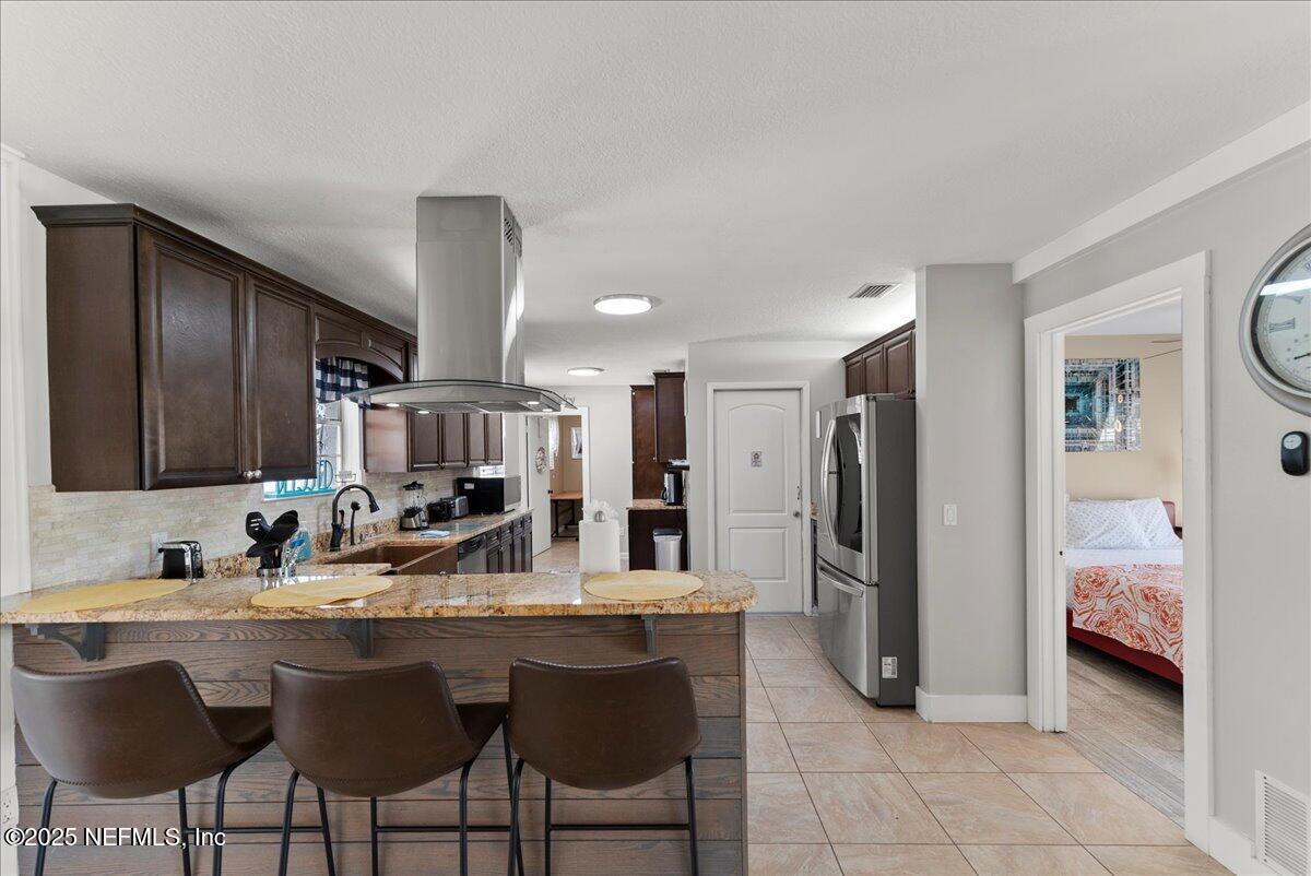 3943 Eunice Road Jacksonville, FL 32250 - Photo 12 of 49 a kitchen with stainless steel appliances kitchen island granite countertop a refrigerator and a sink