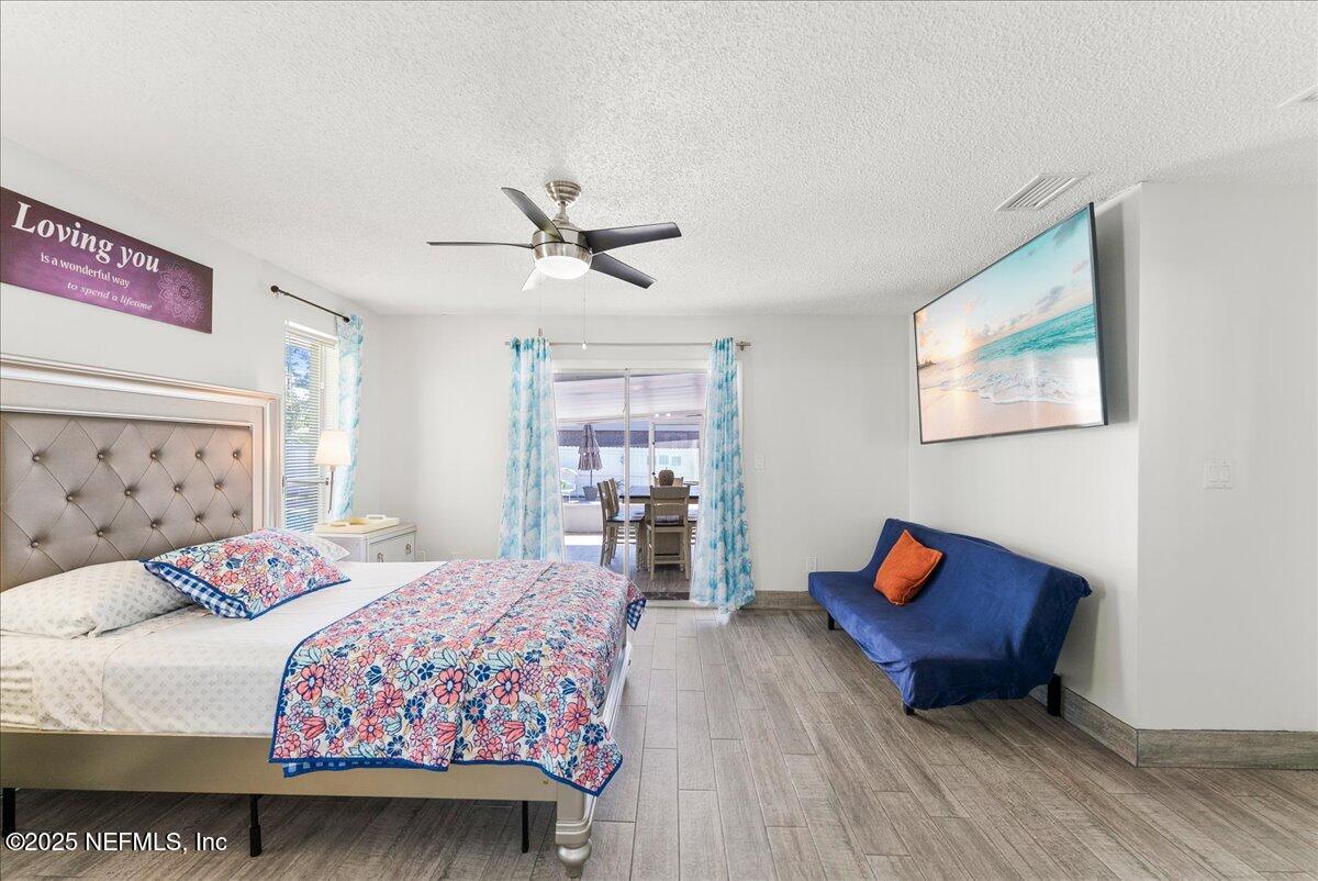 3943 Eunice Road Jacksonville, FL 32250 - Photo 15 of 49 a bedroom with a bed and wooden floor