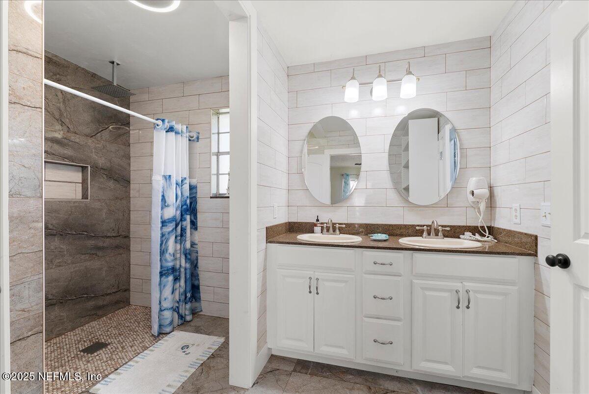 3943 Eunice Road Jacksonville, FL 32250 - Photo 16 of 49 a bathroom with a double vanity sink and mirror