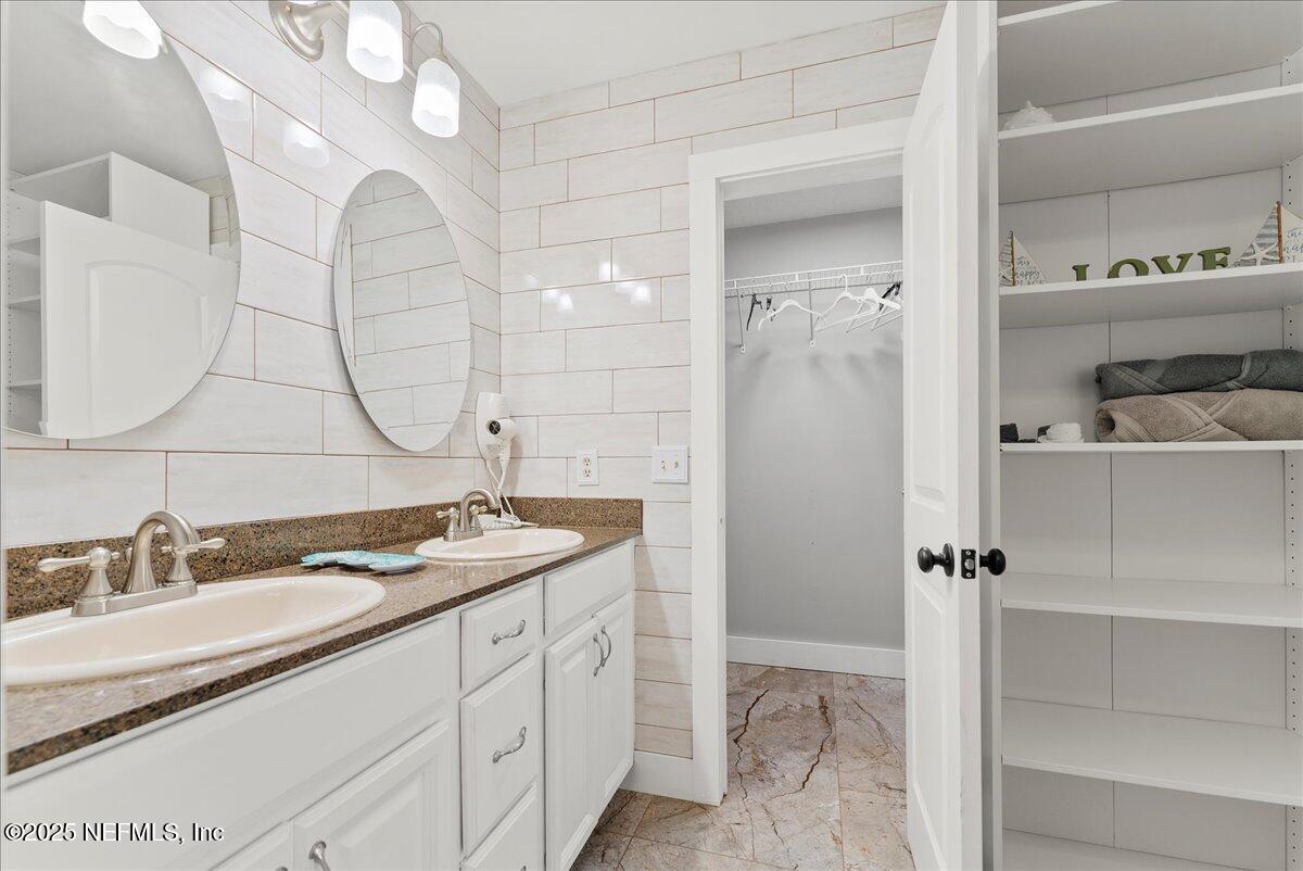 3943 Eunice Road Jacksonville, FL 32250 - Photo 17 of 49 a bathroom with a granite countertop sink a mirror and shower