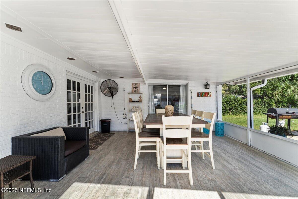 3943 Eunice Road Jacksonville, FL 32250 - Photo 30 of 49 a dining room with wooden floor and large windows
