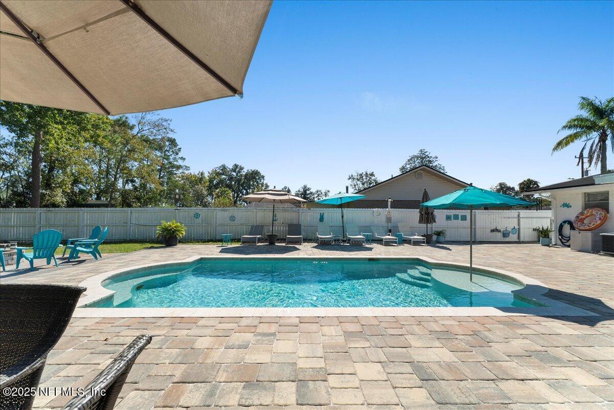 3943 Eunice Road Jacksonville, FL 32250 - Photo 34 of 49 a view of a patio with a table and chairs under an umbrella
