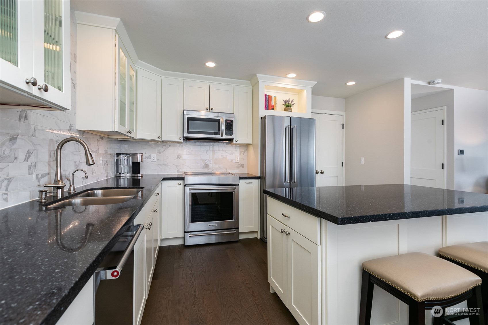 655 Main Street, Unit 301 Edmonds, WA 98020 - Photo 12 of 28 a kitchen with kitchen island granite countertop a sink a counter space stainless steel appliances and cabinets