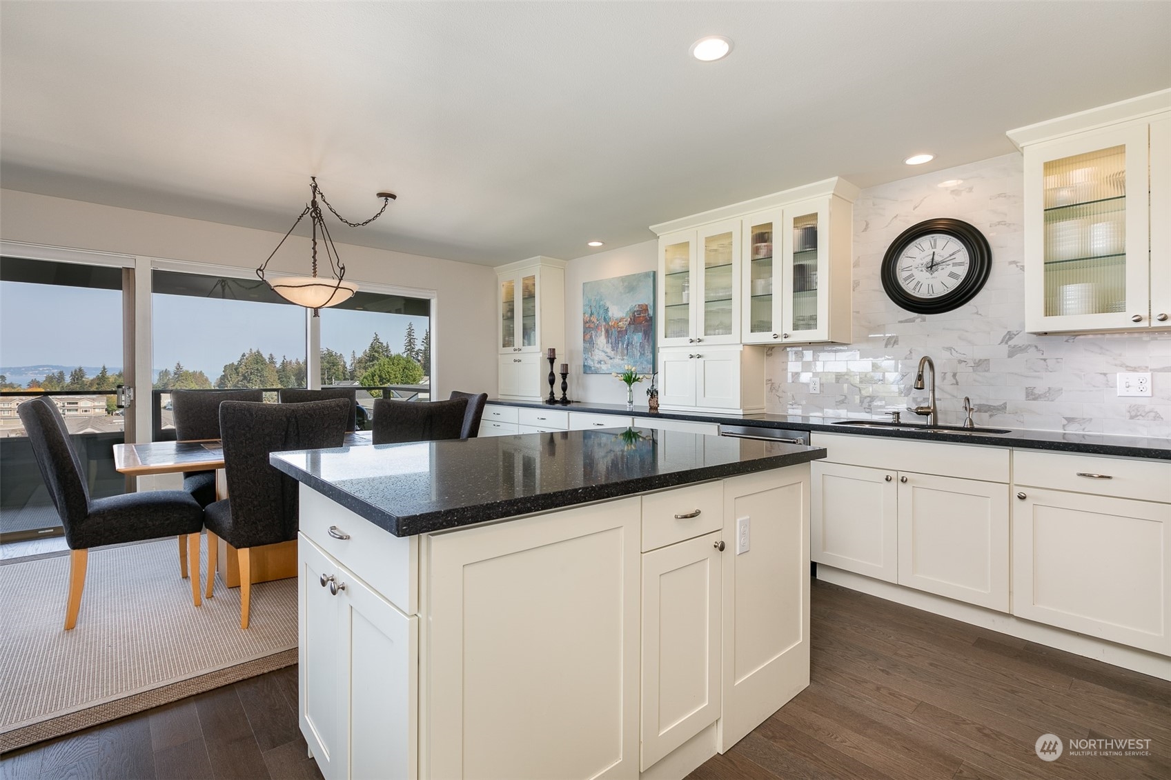655 Main Street, Unit 301 Edmonds, WA 98020 - Photo 13 of 28 a kitchen with granite countertop cabinets a sink and a clock on the wall