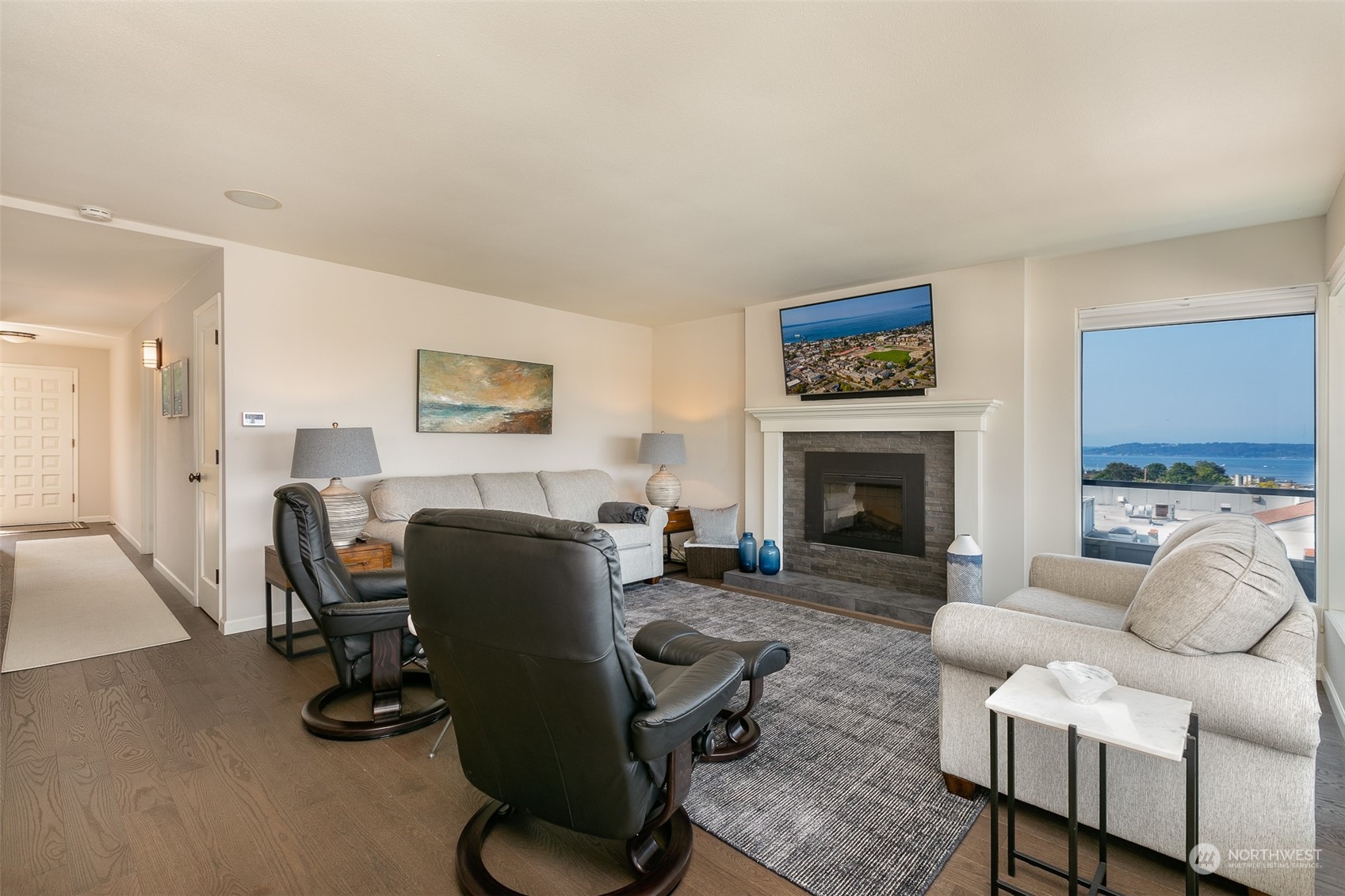 655 Main Street, Unit 301 Edmonds, WA 98020 - Photo 7 of 28 a living room with furniture a fireplace and a flat screen tv