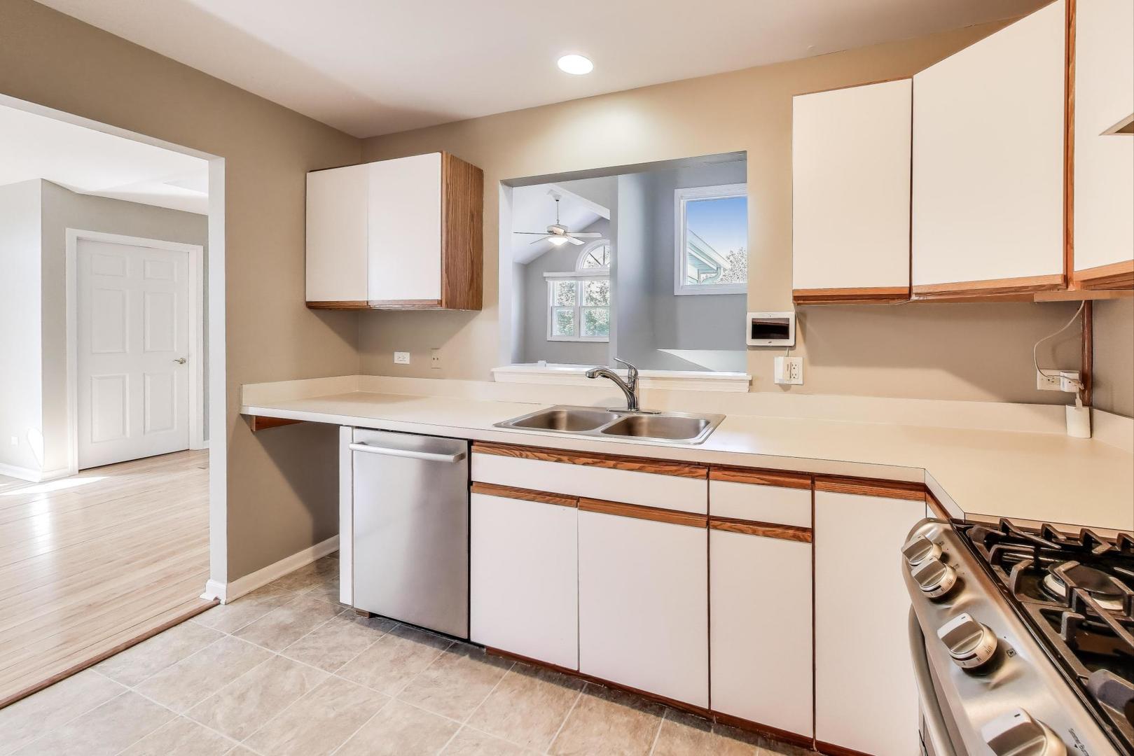 914 Prospect Court, Unit 914 Naperville, IL 60540 - Photo 13 of 38 a kitchen with a sink stove and cabinets