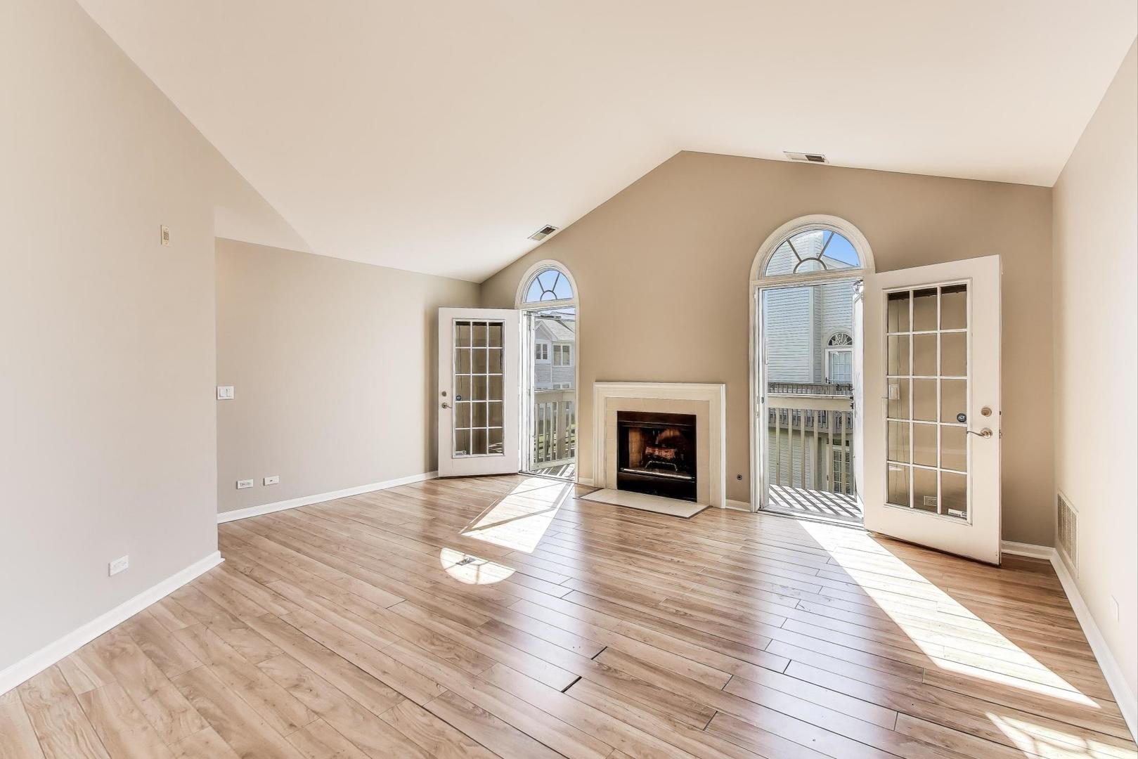 914 Prospect Court, Unit 914 Naperville, IL 60540 - Photo 5 of 38 an empty room with wooden floor fireplace and windows