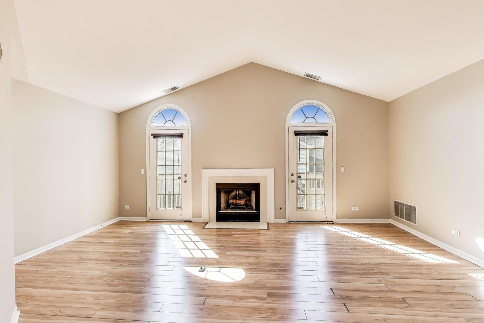 914 Prospect Court, Unit 914 Naperville, IL 60540 - Photo 6 of 38 a view of a livingroom with wooden floor a fireplace and windows