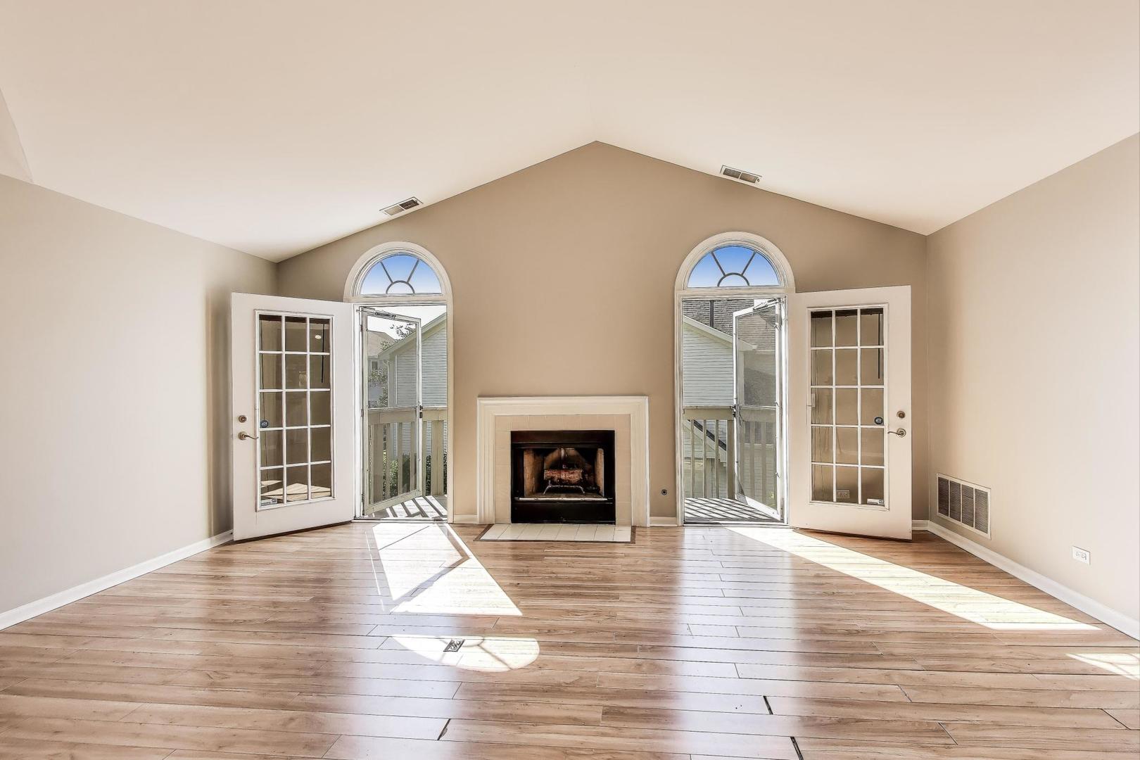 914 Prospect Court, Unit 914 Naperville, IL 60540 - Photo 7 of 38 a view of a livingroom with a fireplace wooden floor and a window