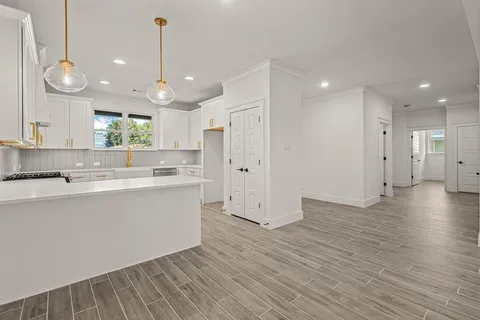 a view of kitchen with wooden floor stainless steel appliances and window