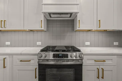 a stove top oven sitting inside of a kitchen