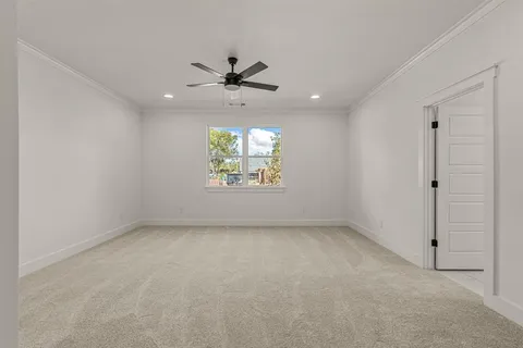 an empty room with a window and a ceiling fan